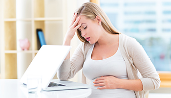 Tired pregnant woman working